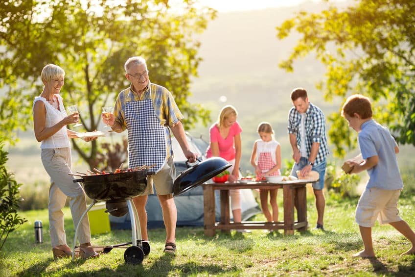 une famille en train de profiter dans un camping à proximité d'un barbecue