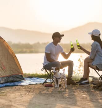 un couple avec une bière à la main dans un camping