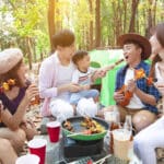 une famille dans une forêt en train de déguster des brochettes